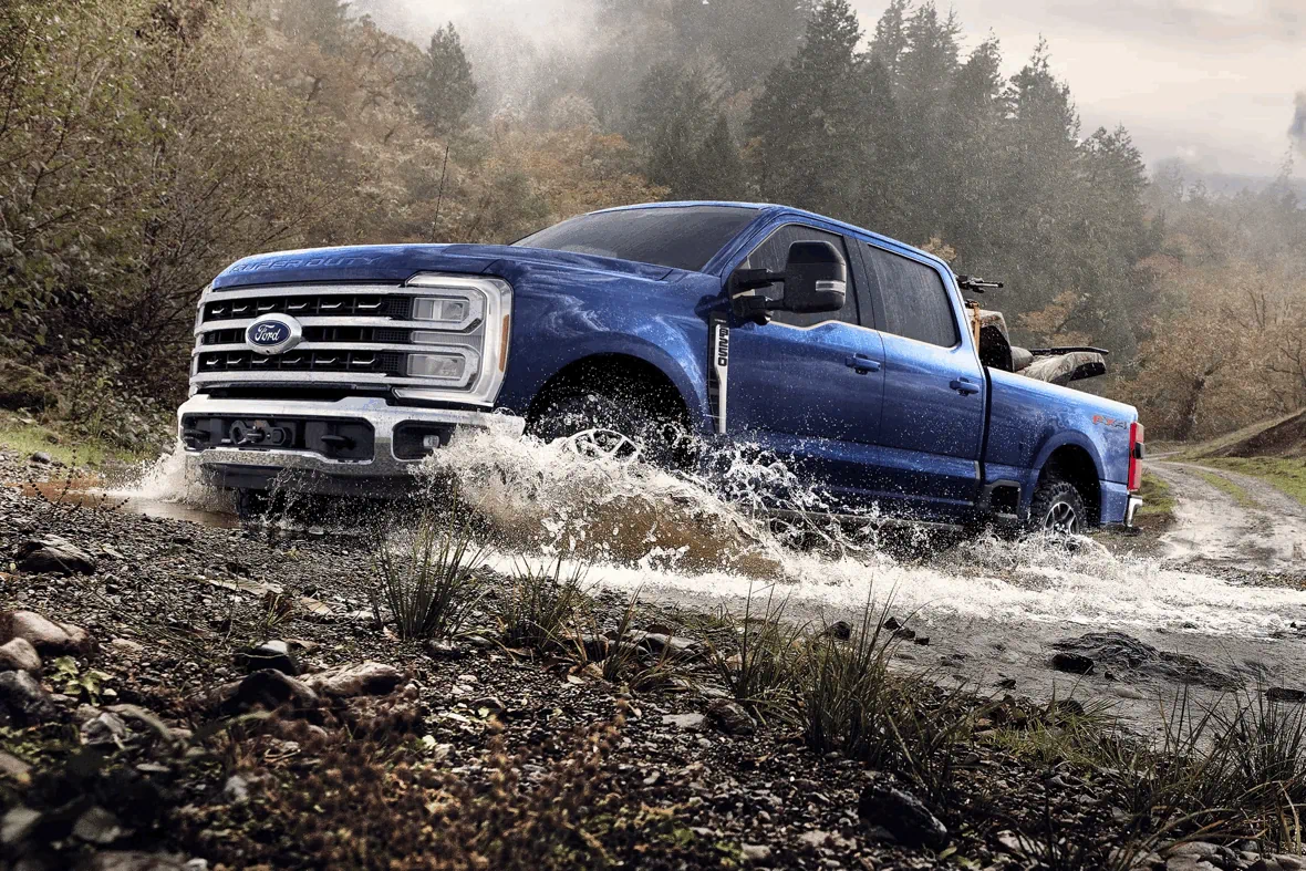 Ford Super Duty F-250 2026 bleu traversant un cours d’eau, camion puissant adapté aux terrains difficiles.