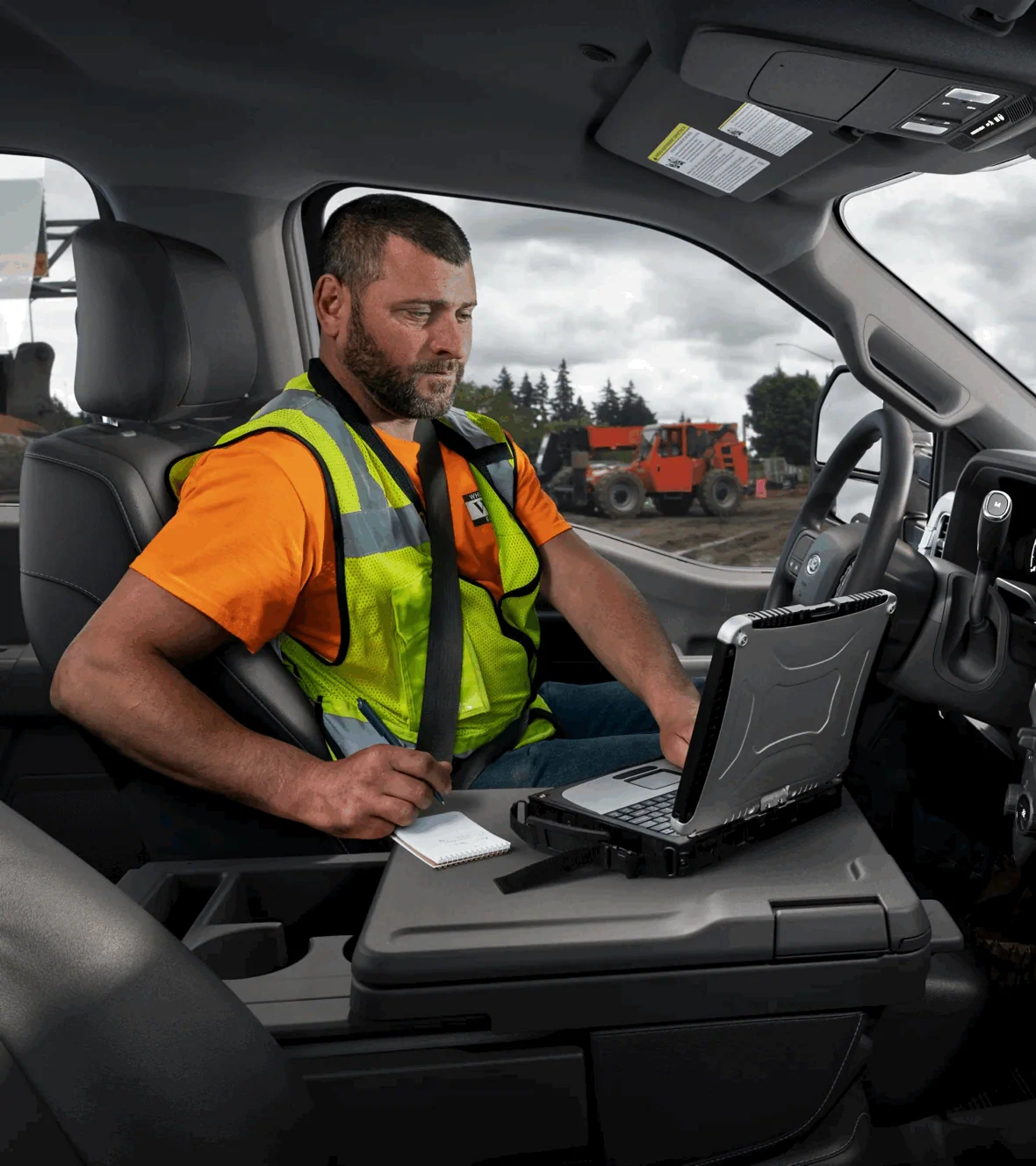 Travailleur dans l’habitacle du Ford Super Duty F-250 2026, camion de travail avec technologies pratiques à bord.