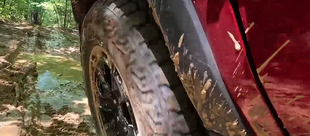 Roue tout-terrain du Ford Bronco Sport 2026 sur un chemin boueux.