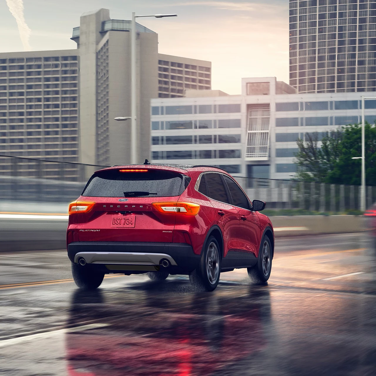 Ford Escape 2026 rouge roulant sur une chaussée mouillée en ville.