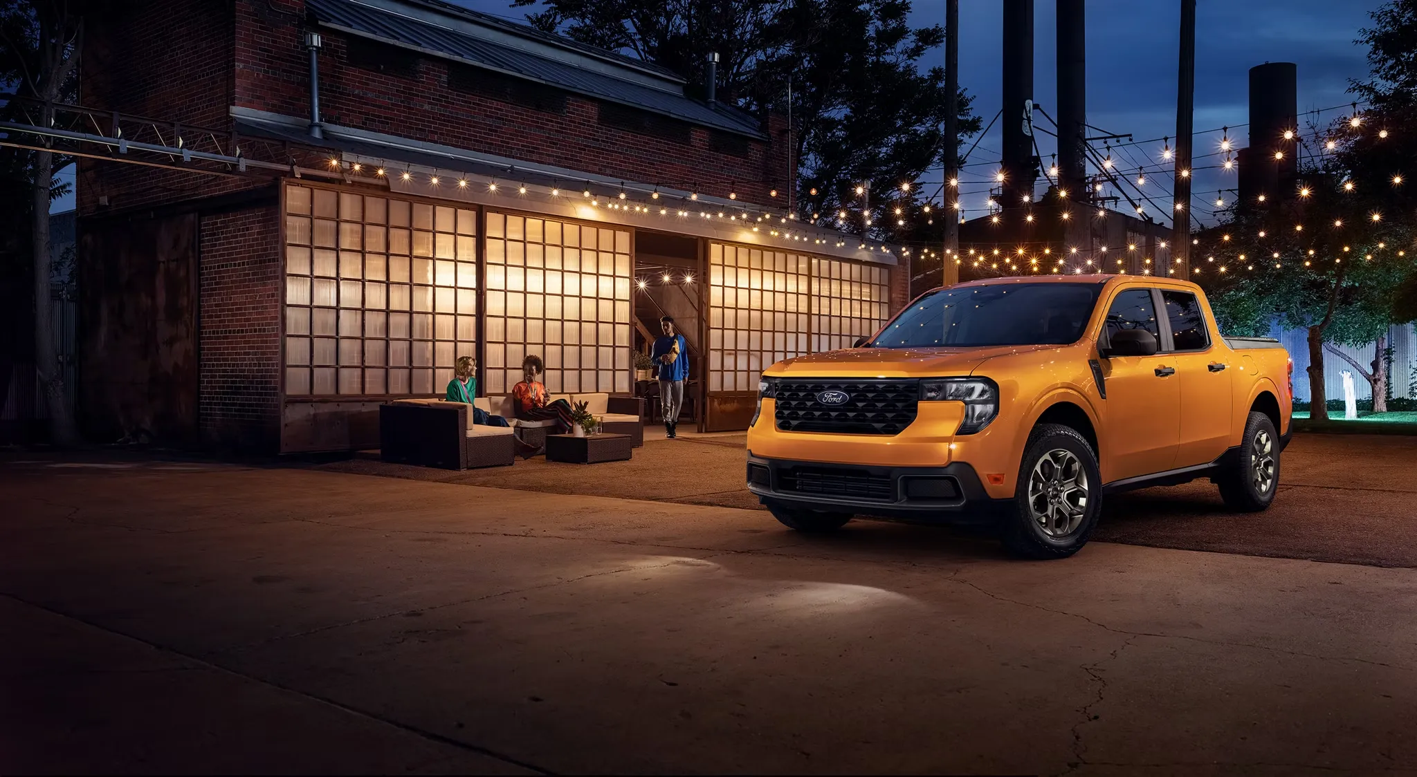 Ford Maverick 2026 orange stationné devant une maison en soirée.