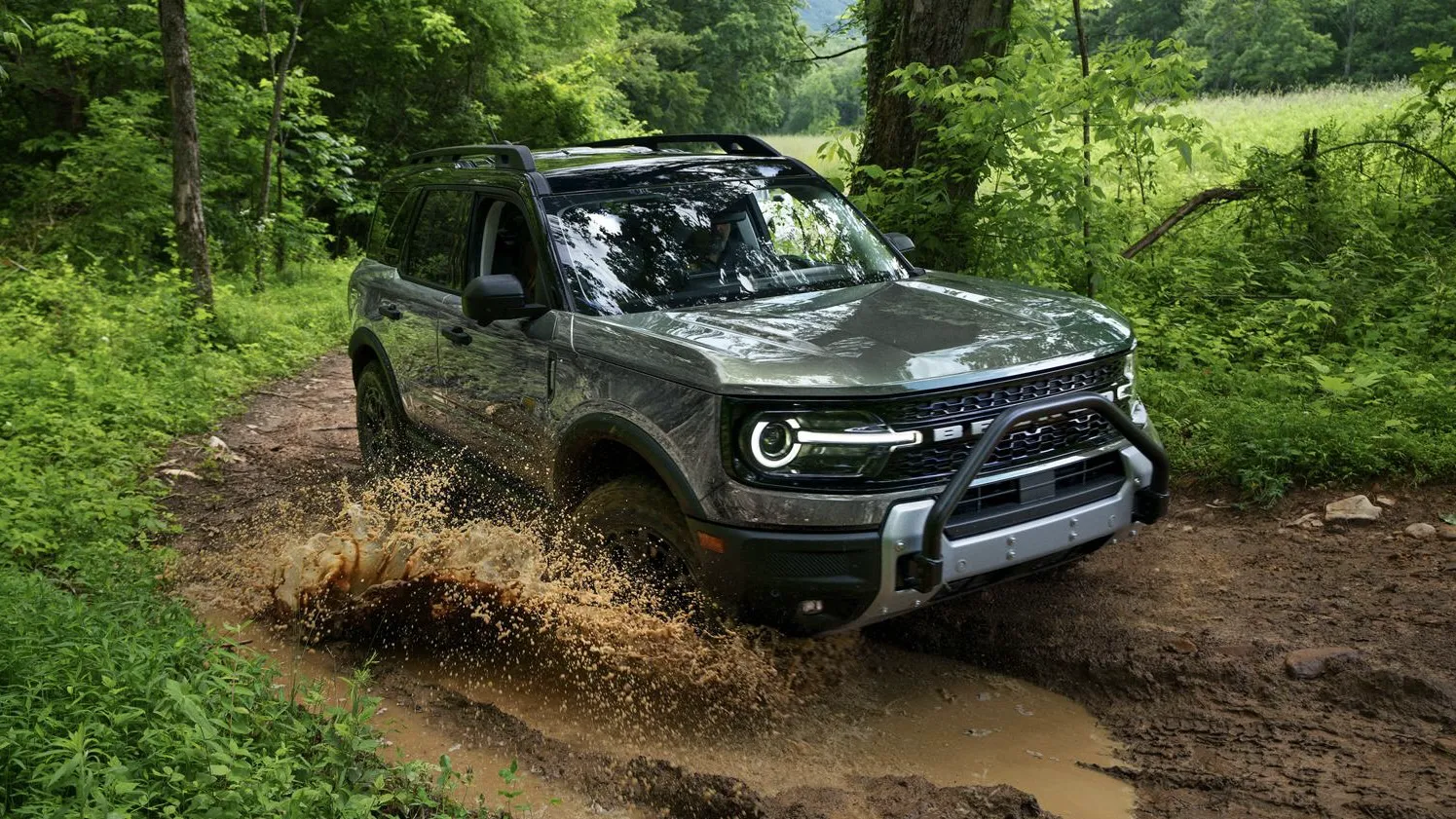Ford Bronco Sport 2026 roulant sur un sentier hors route en forêt.