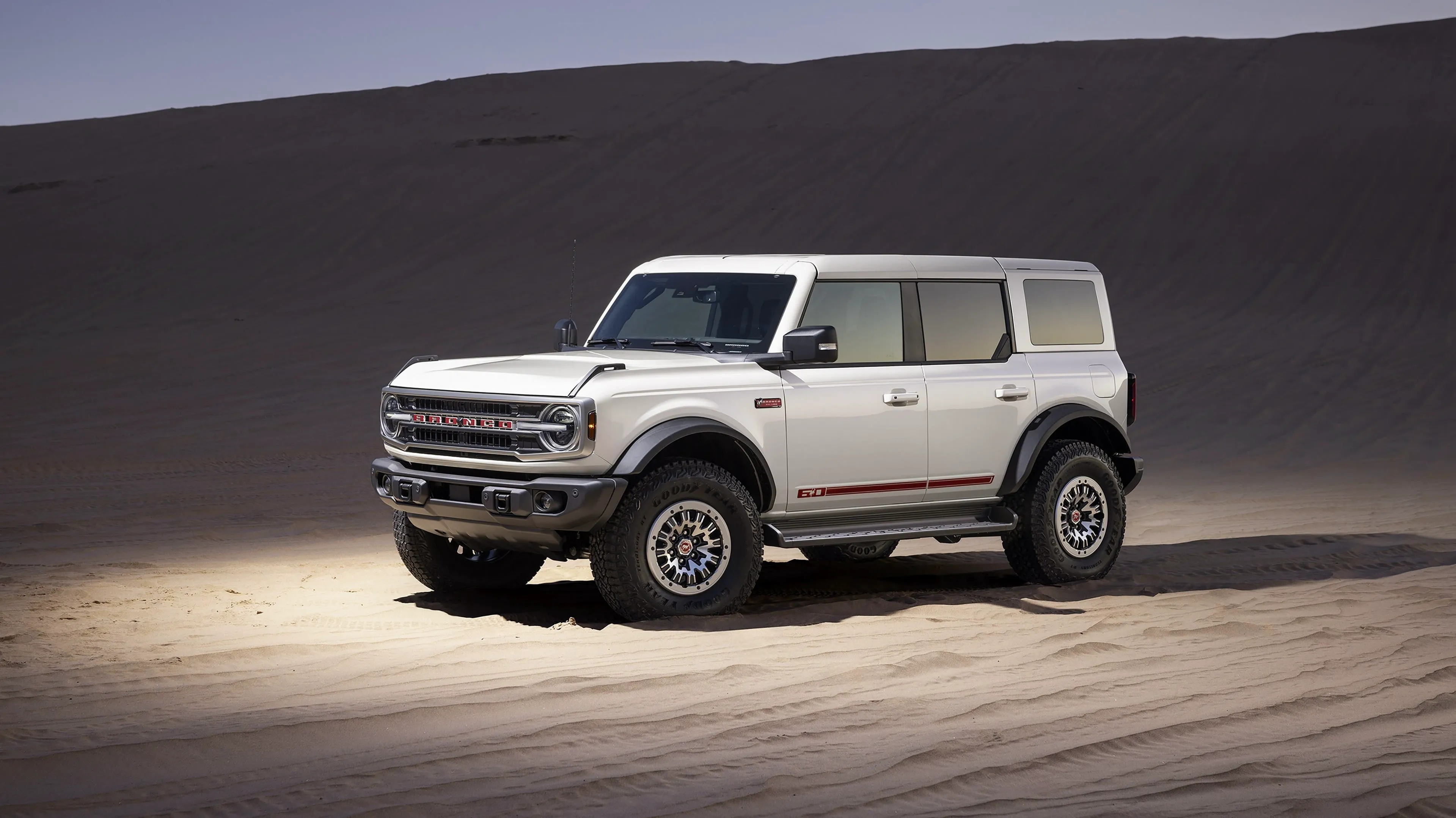 Ford Bronco 2026 blanc en vue trois quarts avant, dans un paysage désertique.