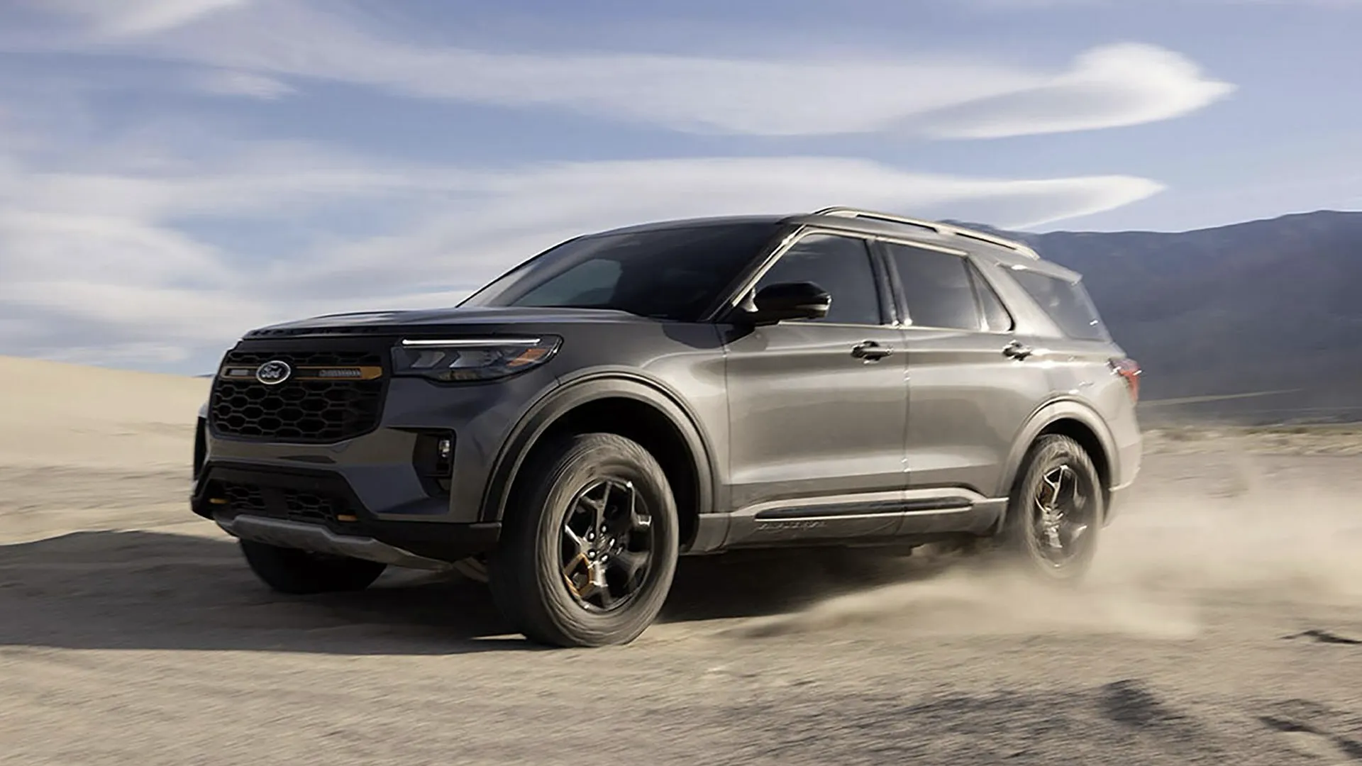 Ford Explorer 2026 foncé roulant sur une route de montagne.