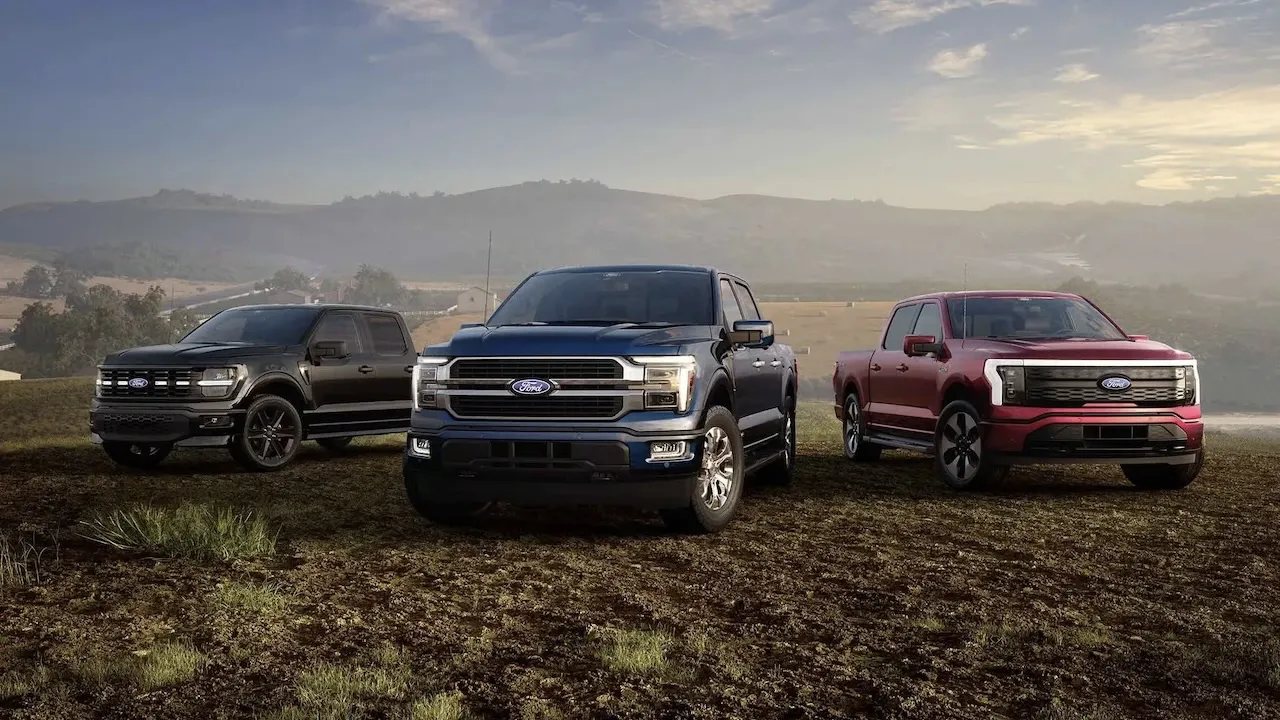 Plusieurs Ford F-150 2026 alignés devant un paysage au coucher du soleil.
