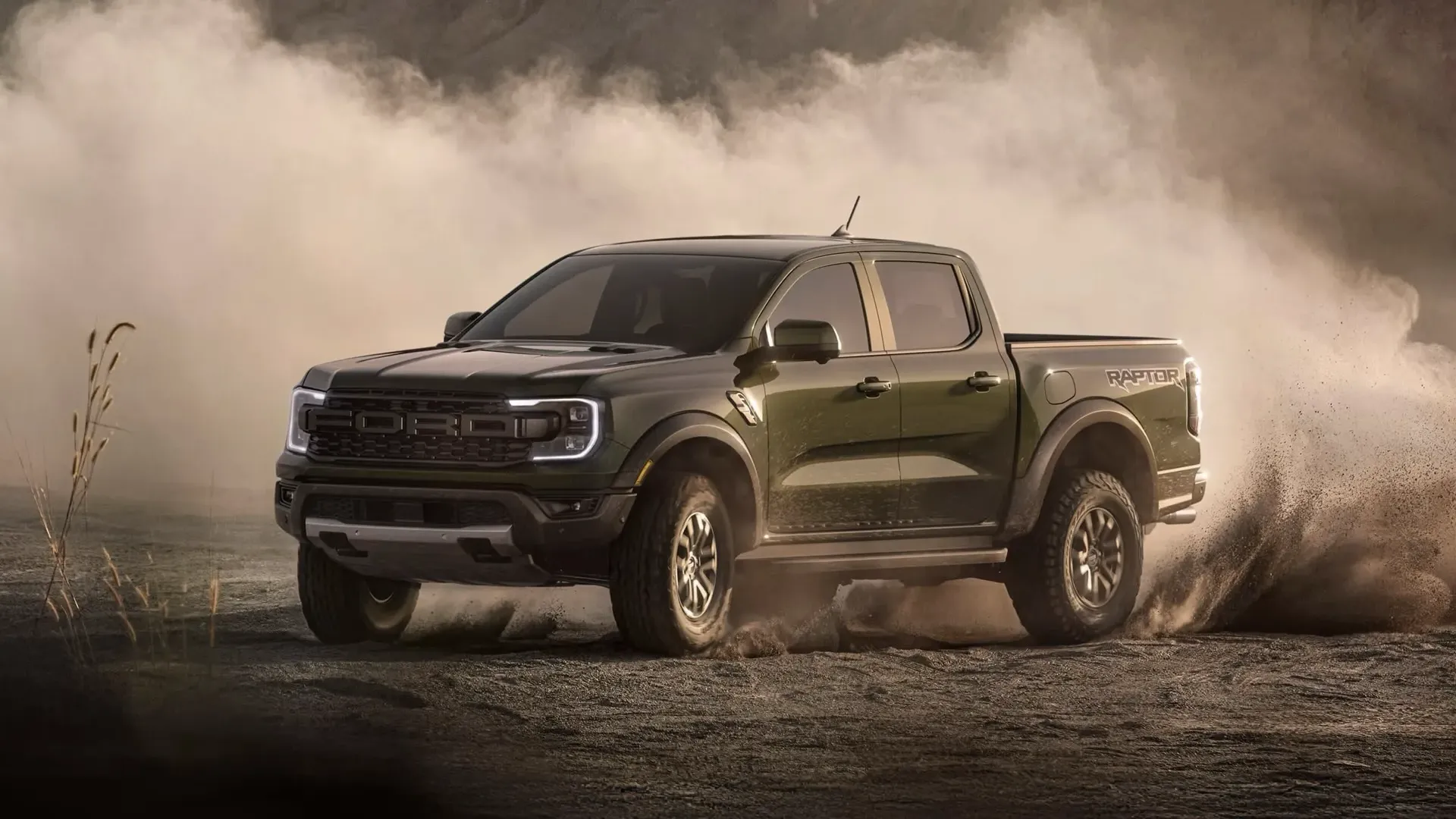 Ford Ranger 2026 vert foncé soulevant de la terre sur un chemin de gravier.